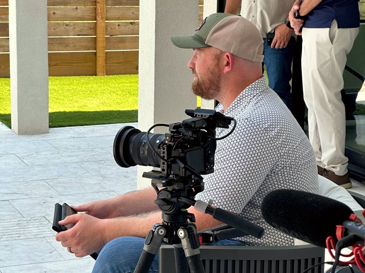 Rex Andrews filming a client testimonial on a finished outdoor living project
